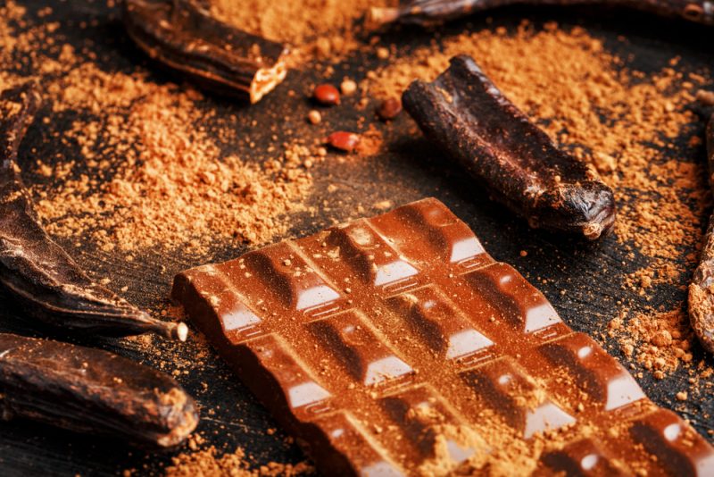 pods of the carob chocolate bar on a black background